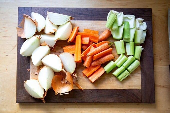 Chopped vegetables — onions, carrots, celery — on a cutting board.