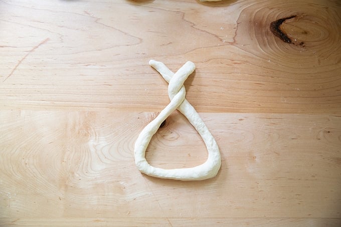 A coil of dough partway twisted into a pretzel.
