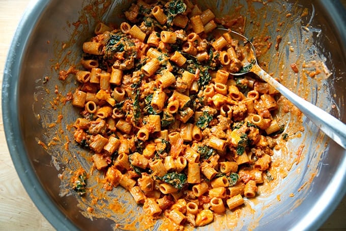 The contents of baked pasta all tossed together in a bowl ready to be transferred to the baking dish.