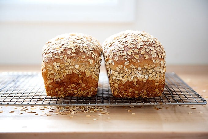 Two loaves of oatmeal maple bread on a cooling rack.