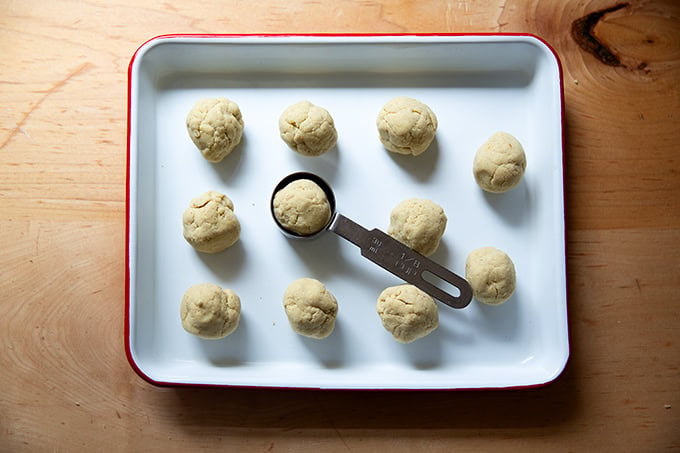 Portioned corn tortilla dough balled up on a tray.
