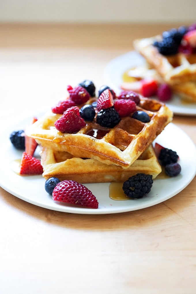 A plate of sourdough discard waffles topped with berries and syrup.