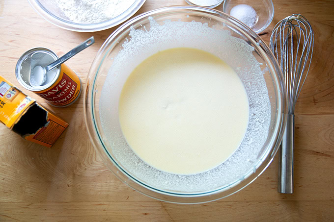 A large bowl filled with the wet ingredients to make sourdough discard pancakes all whisked together.
