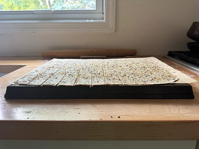 Unbaked sourdough discard crackers on an upside-down sheet pan. 