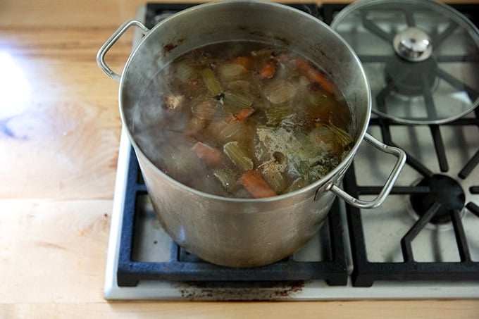 A pot of turkey stock on the stovetop simmering. 