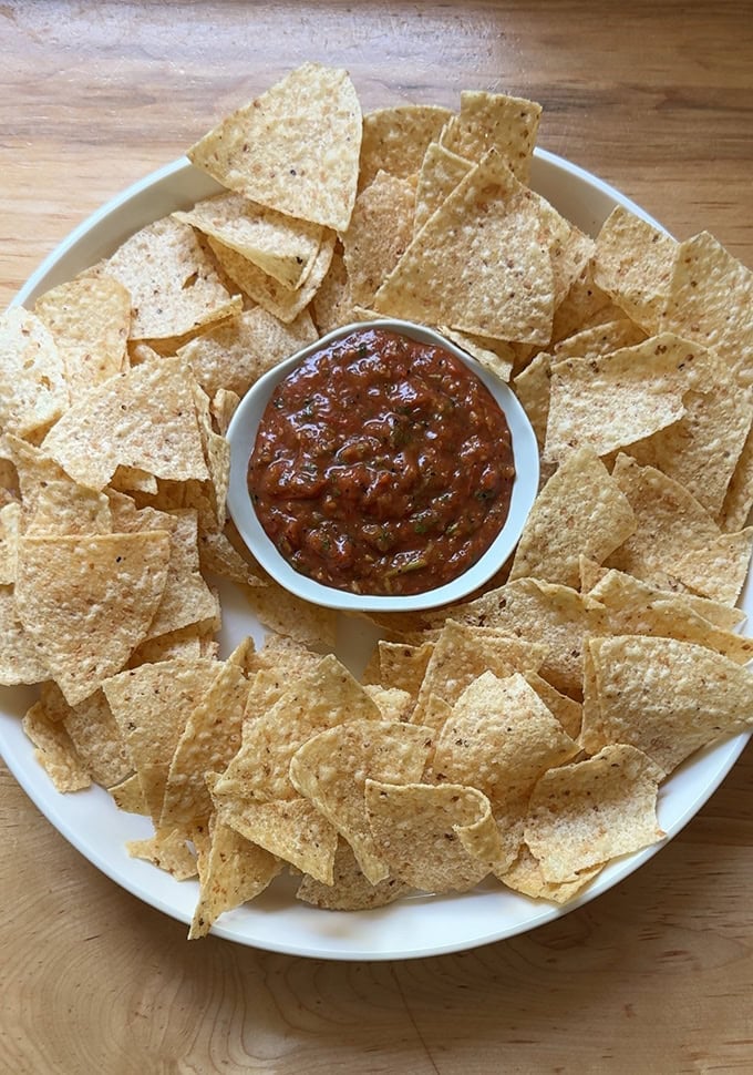 A bowl of chips with charred tomato salsa.
