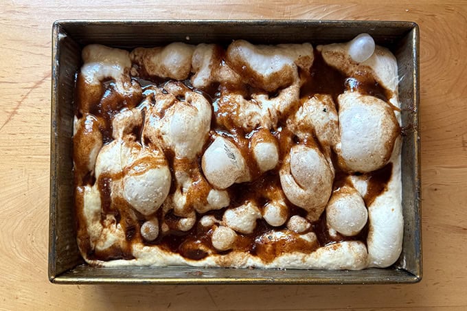 A dimpled cinnamon sugar focaccia ready for the oven. 