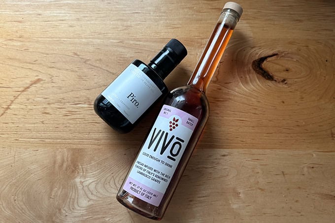 A bottle of Vivo red wine vinegar aside a bottle of Piro extra-virgin olive oil.