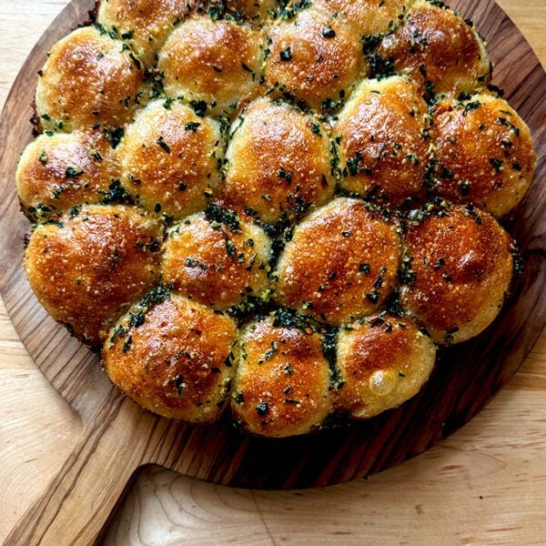 Just baked garlic-herb monkey bread on a cutting board.