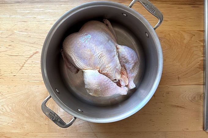 A whole chicken in a large pot.