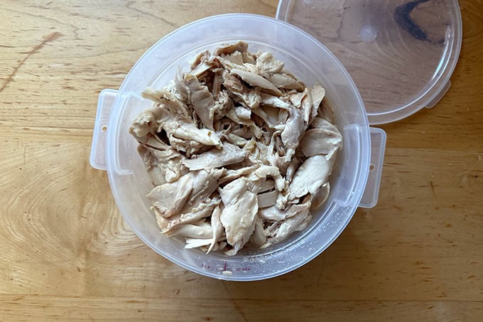 A 2-quart vessel filled with pulled chicken pieces.