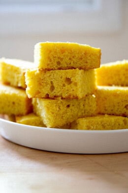 A stack of cornbread pieces on a platter.