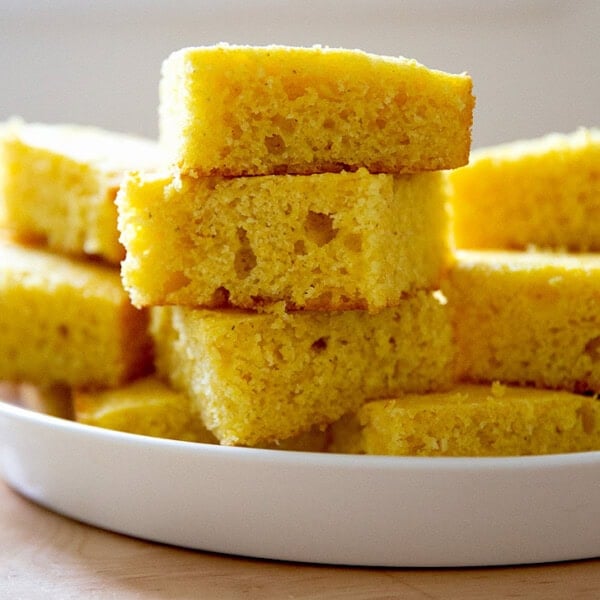 A stack of cornbread pieces on a platter.