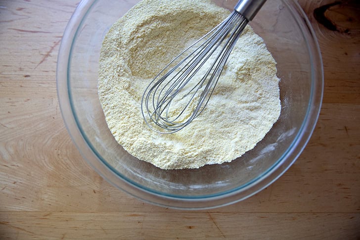 The dry ingredients to make cornbread all whisked together in a large bow.