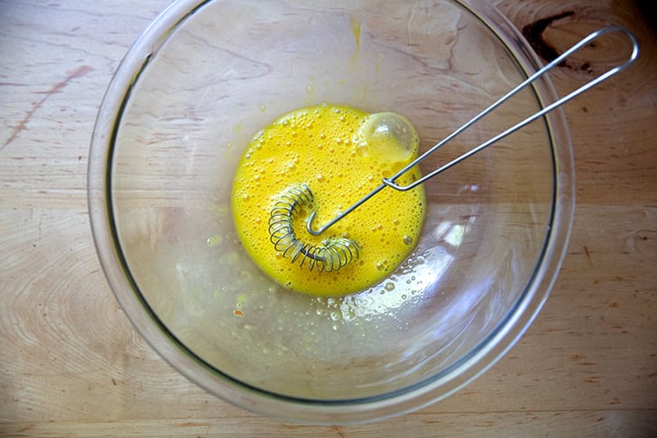 Two eggs beaten together in a large bowl.