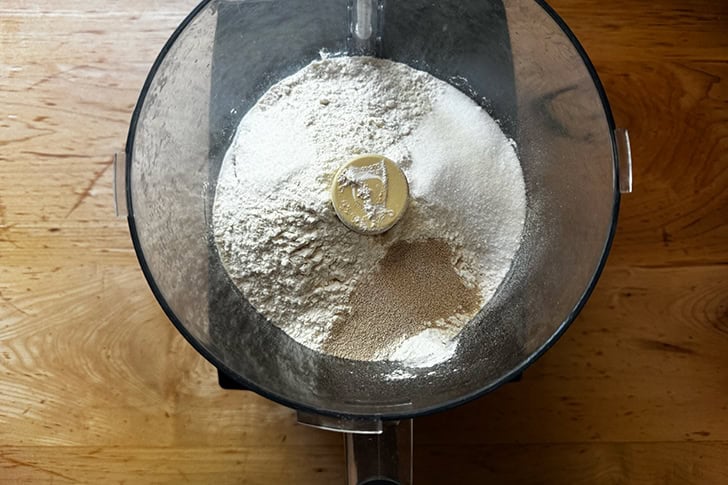The dry ingredients to make cheater's croissant dough in the bowl of a food processor.