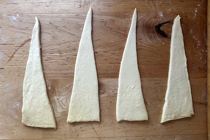 Croissant dough rolled out and cut into 4 triangles.