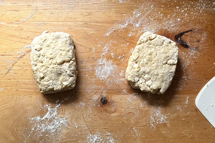 Two portions of croissant dough patted into rectangles.
