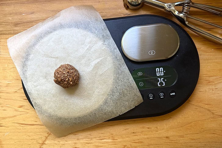 A scale topped with one energy bite weighing 25 grams.