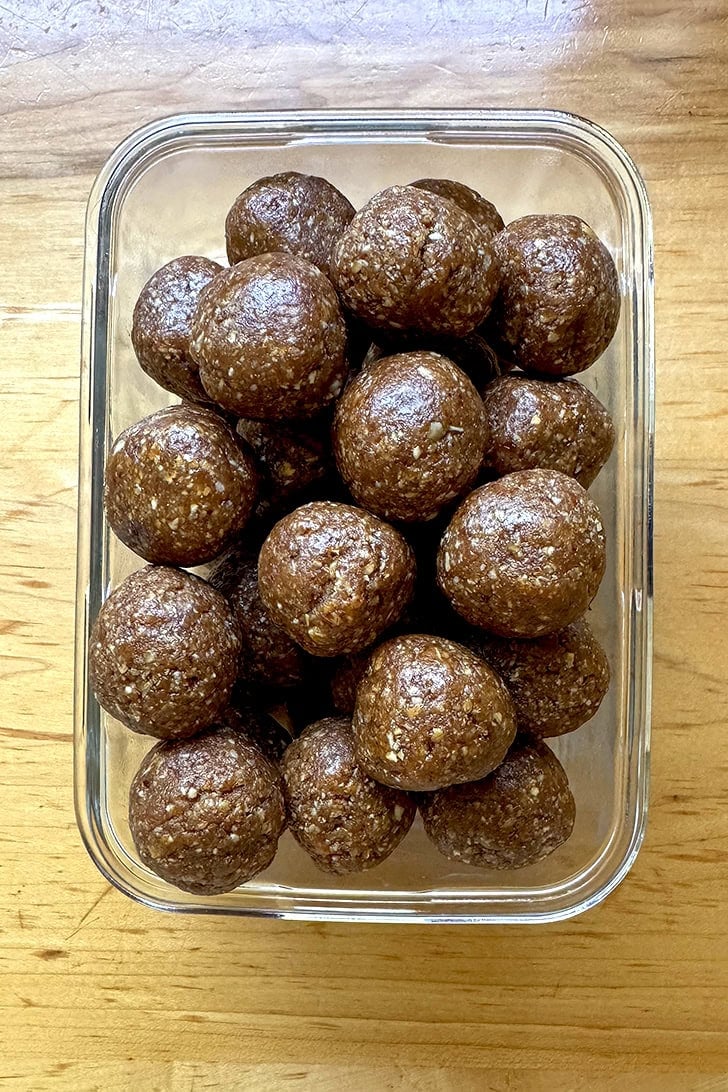A glass storage vessel filled with balls of homemade energy bites.