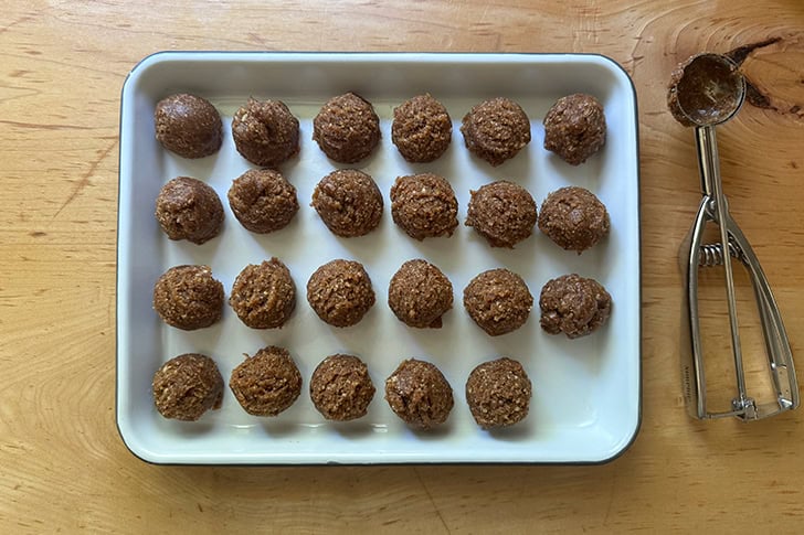 A tray filled with portioned energy bites dough balls.